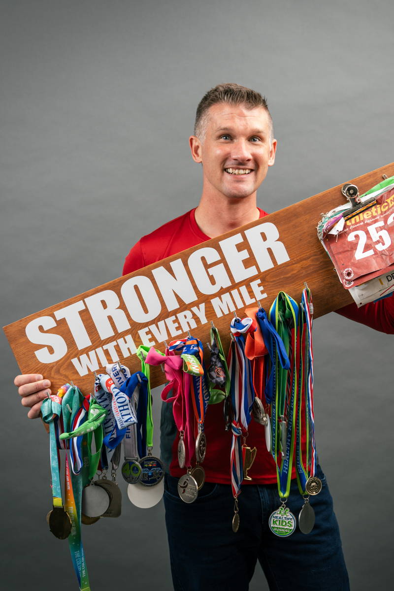 Adam Clarke with his medals for running