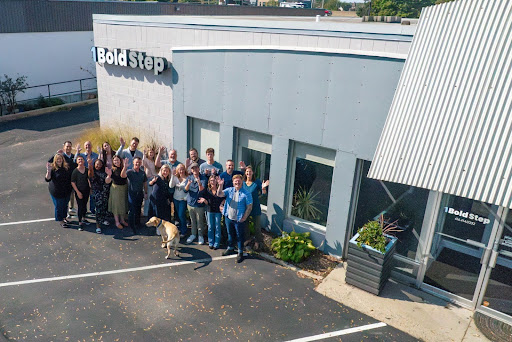 The 1 Bold Step Team in a group photo outside of the building.