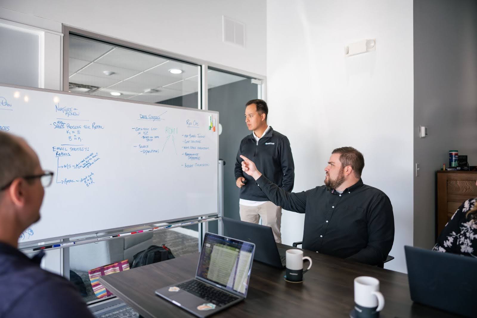 A 1 Bold Step team developing a strategic marketing plan on a whiteboard in a conference room.